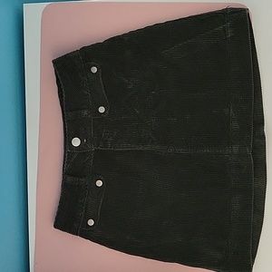 Black corduroy skirt with two mini pockets on the front.